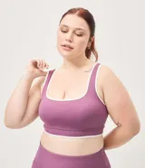 Top deportivo Get Over confeccionado en microfibra color violeta, con escote recto, copa incorporada, breteles anchos y bies contrastante en color blanco. Cuenta con banda acanalada en la base.