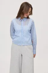 Camisa de manga larga con diseño de rayas verticales en tonos celestes, blancos y marrones, confeccionada en tejido semitransparente con cuello camisero y cierre frontal de botones.
