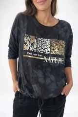 Remera de la línea italiana, color blanco con estampado frontal de animal print en tonos dorados y negros, y la frase "Find your true NATURE". Tiene cuello redondo, mangas largas y cordón regulable en la parte inferior para ajustar el largo.