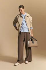 Camisa azul a rayas blancas, de manga larga con puños elastizados, entallada en la cintura y con cierre de botones frontales.