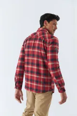 Sobrecamisa de algodón a cuadros color ladrillo, con interior de corderito, cierre con botones, bolsillos tipo cartera y logo en goma. El modelo usa talle M.