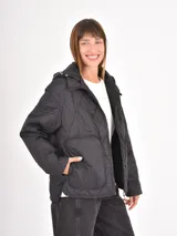 Campera acolchada negra con diseño de costuras romboidales, cierre frontal, capucha ajustable y bolsillos frontales amplios.
