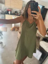 Vestido corto color marrón confeccionado en tusor, con breteles finos y corte holgado.