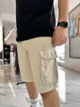 Bermuda cargo de jean color beige, con bolsillos laterales con solapa en las piernas y corte holgado.