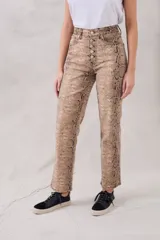 Pantalón de jean de corte recto con estampado de piel de serpiente en tonos beige y marrón. Tiene tiro medio y cierre frontal con botones.
