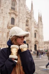 Guantes sin dedos confeccionados en cuero negro con ribetes de corderito al tono en los extremos. Presentan un diseño abrigado y una pequeña etiqueta de marca en el lateral.