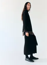 Falda midi negra de punto, de corte recto y tiro alto, con detalle de lazo ajustable en la cintura.