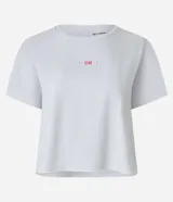 Remera deportiva tipo cropped de microfibra texturizada con mini perforaciones, manga corta y cuello redondo. Presenta una pequeña estampa frontal y detalle contrastante en la espalda.