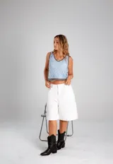 Blusa de crochet color beige con diseño calado, escote en V y terminaciones en color negro en el cuello, sisas y ruedo.