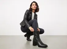 Botas de caña corta confeccionadas en cuero negro con textura granulada, diseño de punta cuadrada y taco bloque de altura media.