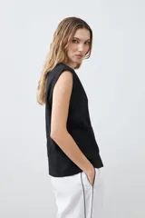 Chaleco negro con cuello en V y cierre frontal con botones. Confeccionado en lino.