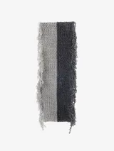 Bufanda tejida en punto grueso, dividida verticalmente en dos colores: beige claro y marrón. Presenta flecos largos y deshilachados en los bordes laterales.