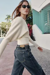 Jersey de punto color verde lima, con cuello pico y manga larga de sisa ancha que se estrecha hacia la muñeca.