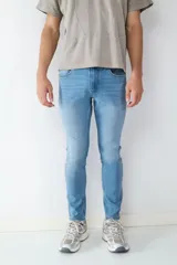 Jean de corte slim fit en color azul claro, con diseño clásico de cinco bolsillos, cierre frontal con botón y cremallera.