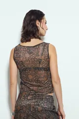 Top sin mangas ajustado al cuerpo, color negro, con estampado animal print abstracto en tonos marrones y negros. Presenta un escote cerrado y es de tejido traslúcido.