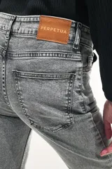 Pantalón jean gris de tiro medio alto, corte wide leg con tajo frontal.