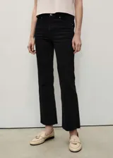 Jeans de tiro alto estilo flare y diseño crop, color negro, confeccionados en denim con cinco bolsillos, trabillas para cinto y bajo deshilachado.