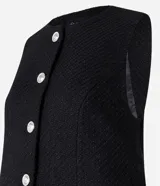 Chaleco blanco de tweed con cuello redondo, abotonado en el frente y corte entallado.