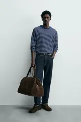 Camiseta de manga larga con cuello redondo y efecto lavado. Presenta un patrón de rayas horizontales finas en azul marino y blanco/beige.