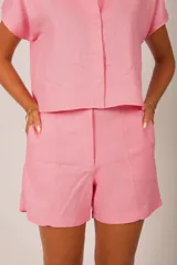 Short de lino verde lima, de tiro alto, con trabillas para cinto y bolsillos laterales.