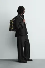 Sobrecamisa de corte relajado confeccionada en tejido efecto piel color marrón oscuro. Presenta cuello solapa, cierre frontal con botones metálicos, mangas largas con puños abotonados y dos bolsillos de plastrón con solapa en el pecho.