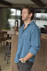 Camisa celeste de lino con cuello clásico, manga larga con puños abotonados y cierre frontal con botones.