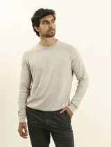 Sweater de punto color naranja, con cuello redondo y mangas raglán.