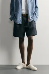 Bermuda regular fit azul marino confeccionada en lino, con bolsillos frontales, bolsillos traseros de doble vivo con botón y cierre frontal con cremallera y botón.
