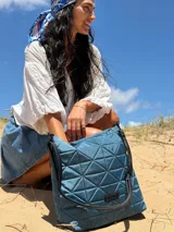 Cartera capitoneada color beige, con diseño geométrico y asa resistente. Amplia y cómoda, ideal para el uso diario.