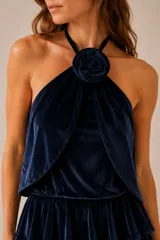 Top de terciopelo color azul marino, con escote halter y detalle de flor desmontable en el cuello.