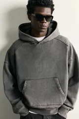 Sudadera con capucha de corte relajado, confeccionada en tejido de algodón con efecto lavado. Presenta manga larga, bolsillo frontal tipo canguro y terminaciones en rib.
