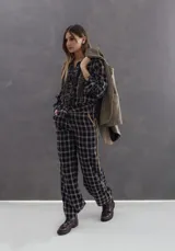 Pantalón de corte recto con estampado de cuadros escoceses en tonos negro y blanco. Presenta una franja lateral en color camel, pretina a juego y bolsillos laterales.