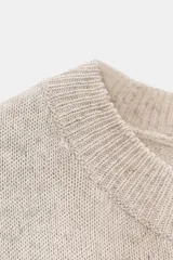 Top de punto color crema, de cuello redondo y sin mangas.