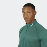 Remera deportiva de manga larga, color verde bosque, con cuello alto y cierre frontal de un cuarto. Presenta paneles de micromalla en el pecho y mangas raglán.