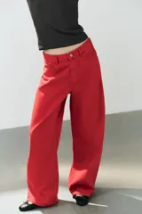 Jeans estilo baggy oversize de tiro medio en color rojo, con cinco bolsillos, trabillas para cinto y costuras decorativas marcadas en las piernas.