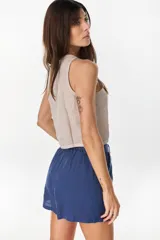 Top musculosa amarillo de lino italiano, con cuello redondo y cierre frontal de botones de nácar.