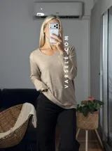 Sweater de punto color bordó con escote en V y detalle de strass aplicado en la parte frontal. Presenta mangas largas y corte holgado.