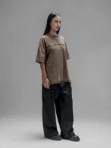 Remera de manga corta con diseño oversize, confeccionada en algodón con proceso batik artesanal en tono óxido. Presenta recortes superpuestos en el frente y costuras expuestas en mangas y cuerpo.