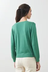 Sweater verde de tejido de punto, con escote en V y mangas largas.