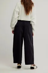 Pantalón de denim blanco de tiro medio con cintura elástica ajustable mediante cordón, bolsillos plaqué delanteros y diseño de corte amplio y holgado.