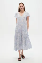 Vestido midi de viscosa con estampado floral en tonos celeste y blanco, cuello en V, mangas cortas y diseño holgado con volados en la falda.