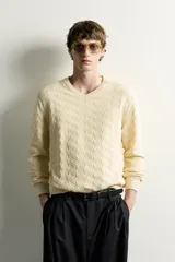 Jersey de punto regular fit color beige, con cuello redondo y diseño de textura geométrica en zigzag.