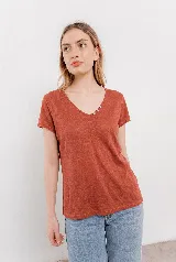 Remera de lino color ladrillo, con escote en V y detalle de tres botones decorativos en el lateral del escote. De corte holgado y manga corta.