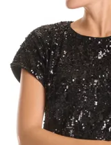 Blusa de manga corta con cuello a la base, completamente cubierta de lentejuelas negras. Cuenta con forro interno a tono.