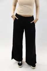 Pantalón deportivo negro de corte wide leg, con cintura elástica, bolsillos laterales y aberturas en los bajos.