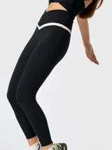 Calza deportiva de corte ankle, color negro, con cintura alta en forma de V y detalle bicolor en contraste. Confeccionada en poliéster con elastano y tecnología Aloe Vera para mayor suavidad.