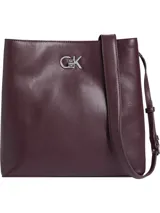 Cartera tipo saco Calvin Klein color borgoña, con correa larga regulable y logo CK plateado en el frente.
