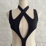 Body negro con escote halter cruzado y abertura en el abdomen.