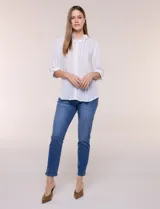 Camisa de calce holgado en género liviano con estampado a rayas verticales, cuello camisero clásico y abotonadura frontal a tono. Presenta mangas largas regulables con presilla y botón para ajustar a tres cuartos, espalda con canesú y suave pliegue central, y ruedo curvo estilo camisero.