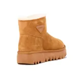 Bota corta de gamuza color tostado, con forro interno de corderito sintético, suela de goma plataforma acanalada y aplique triangular con la marca "Country" en el lateral.